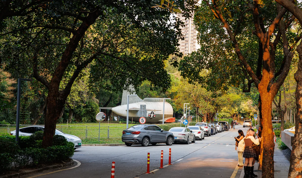 Tree-lined street and an aircraft display at OCT LOFT in Shenzhen