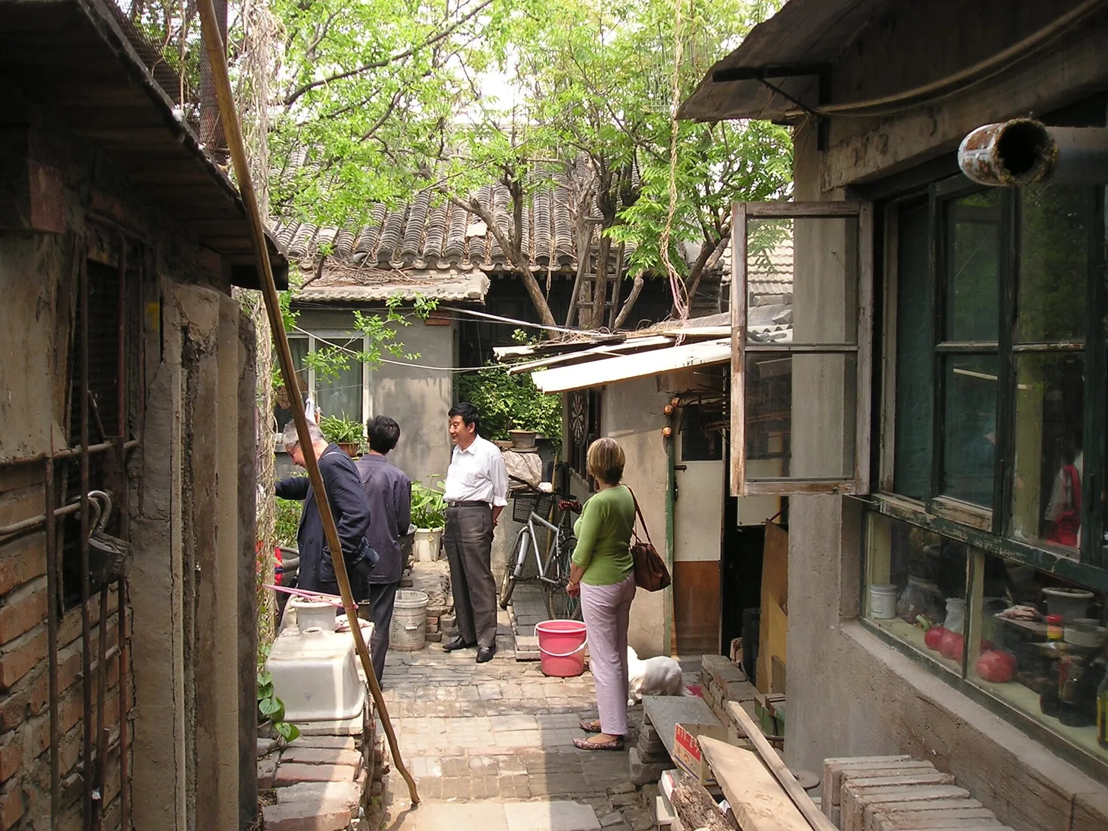 Visitors walking through a narrow Beijing hutong courtyard